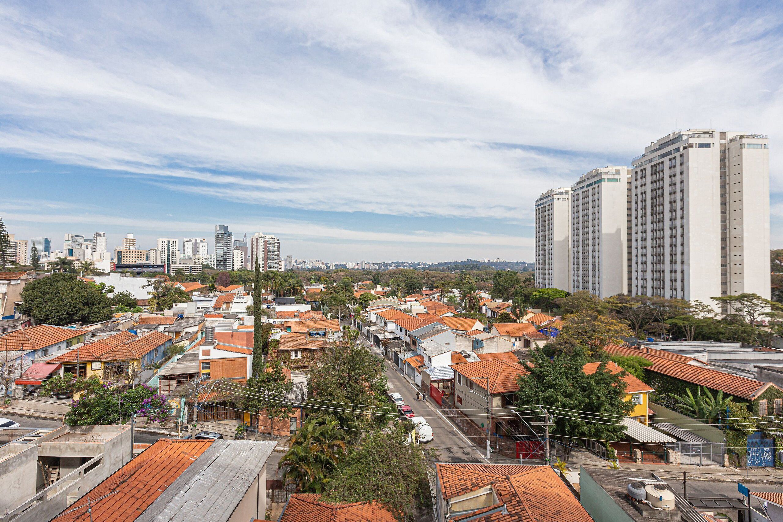 A residential area with red-tiled roofs, a mix of single and multi-story buildings, and a clear sky.