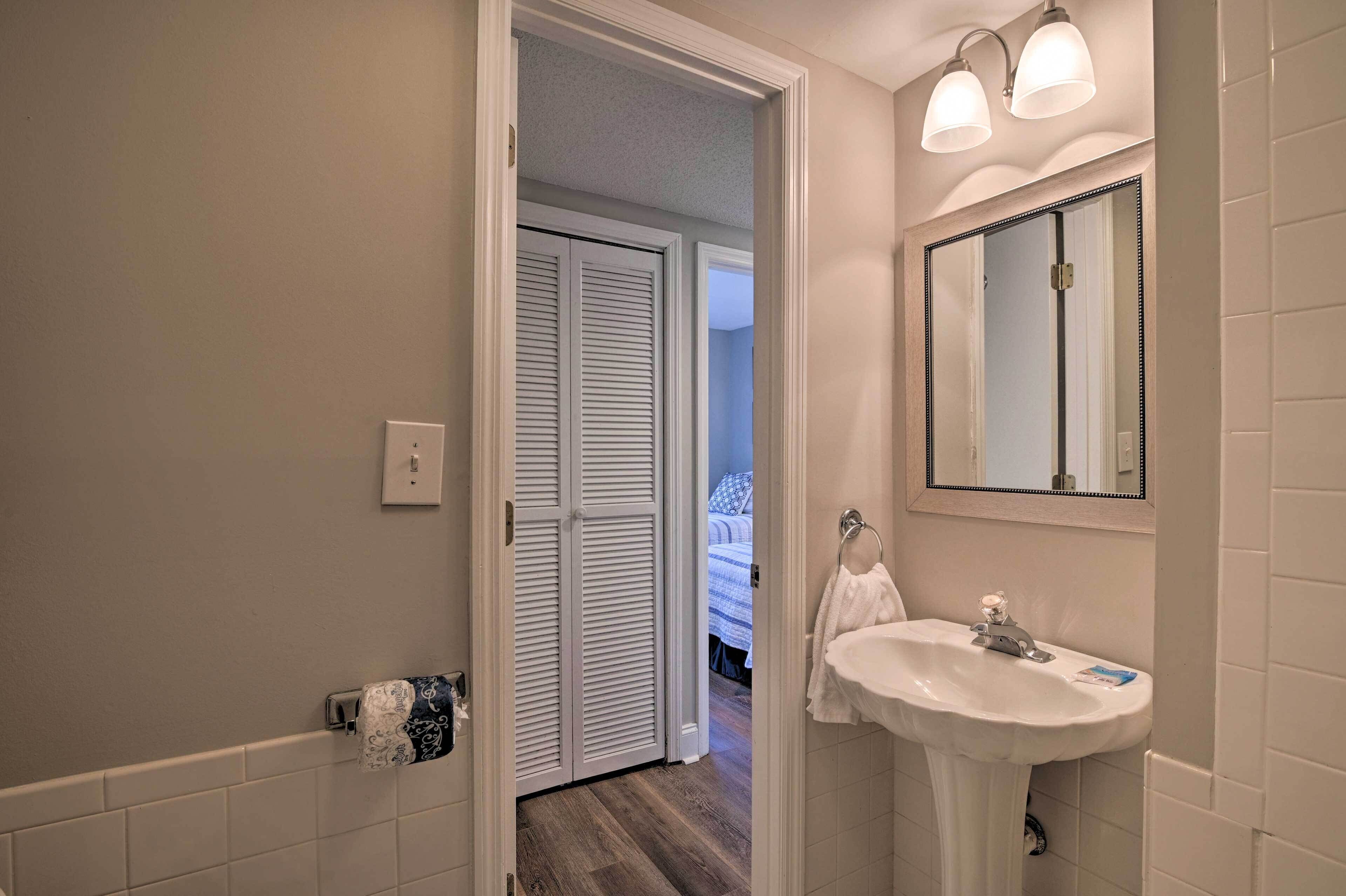 A bathroom with a white sink, a mirror, and a towel rack.