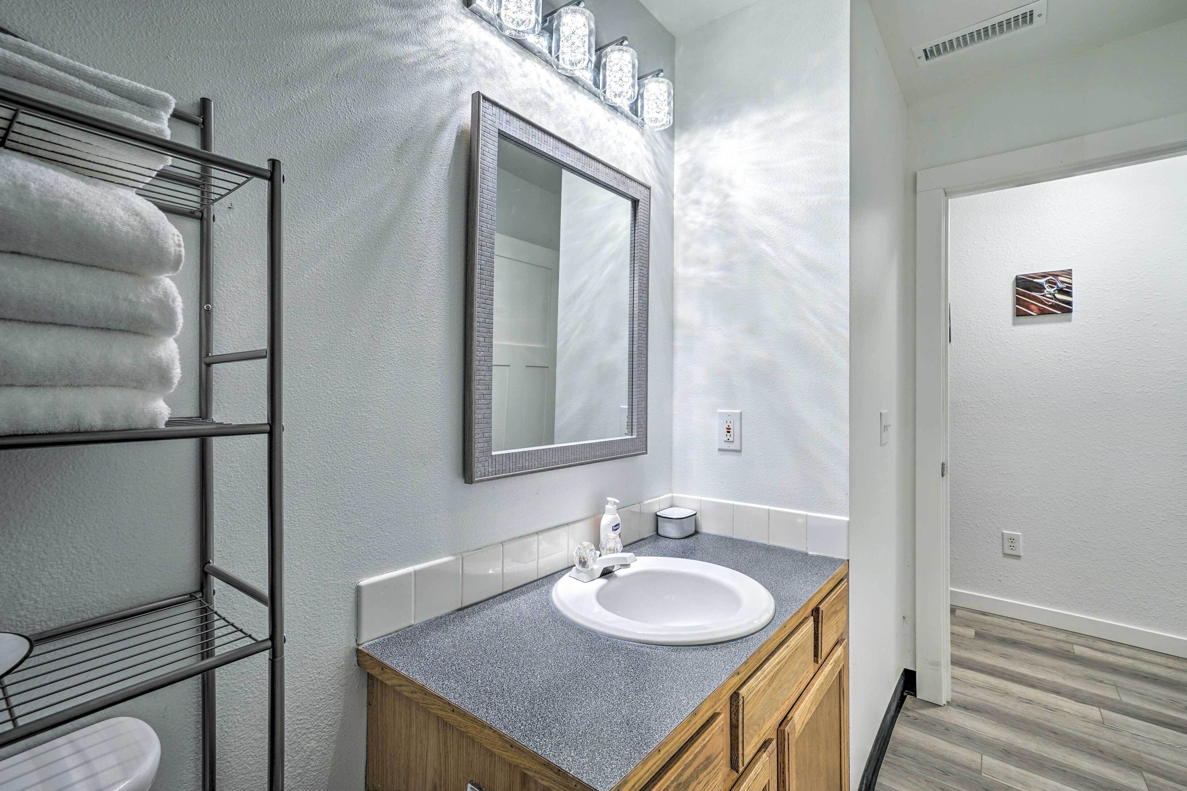 A bathroom with a white sink, a mirror, and a towel rack.