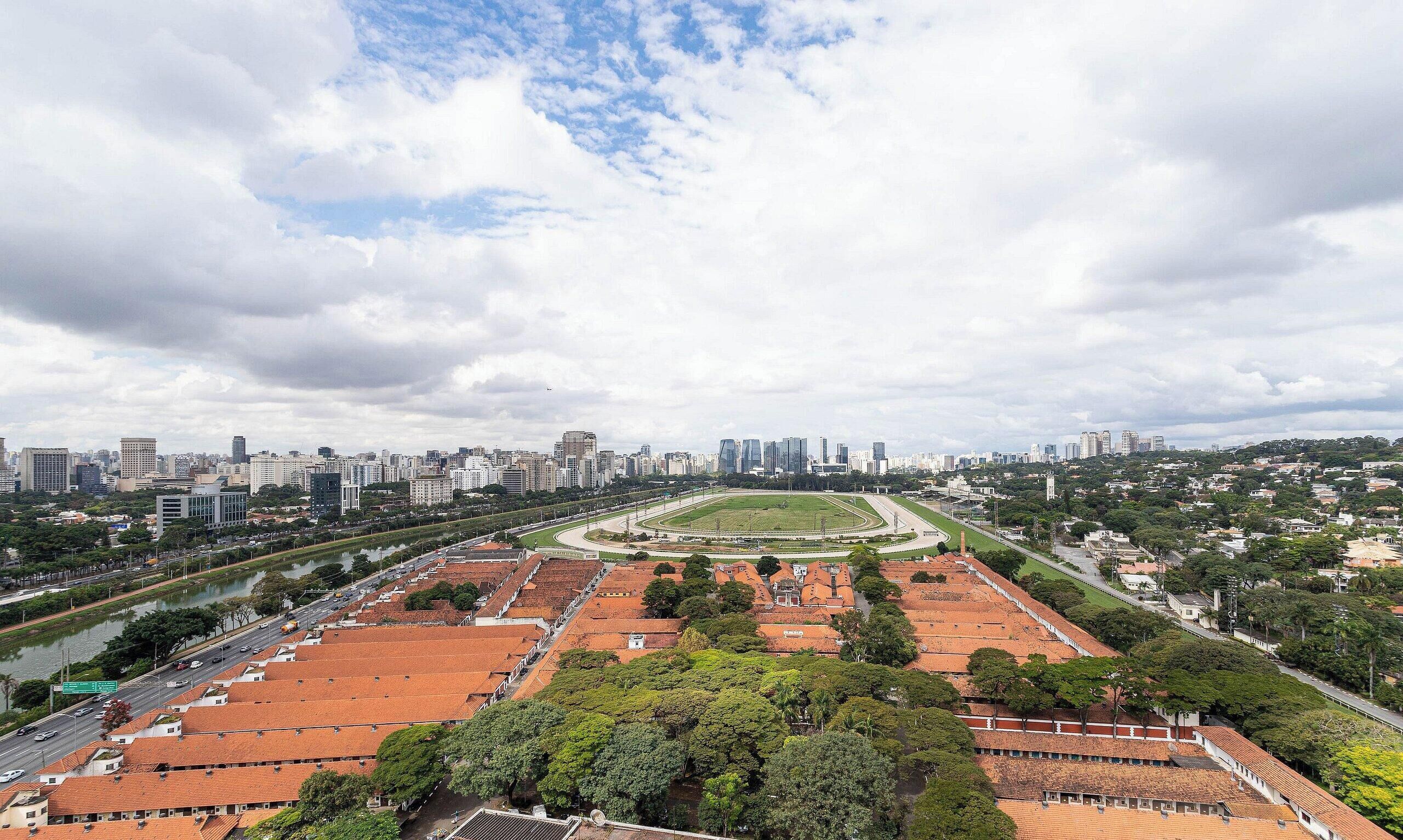 A cityscape with a large open park area, modern buildings, and a river.