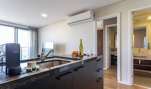 A modern kitchen with a large island, built-in appliances, and a view to the outside.