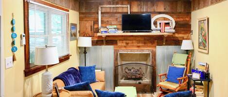 Una sala de estar acogedora con chimenea, televisor y asientos cómodos.