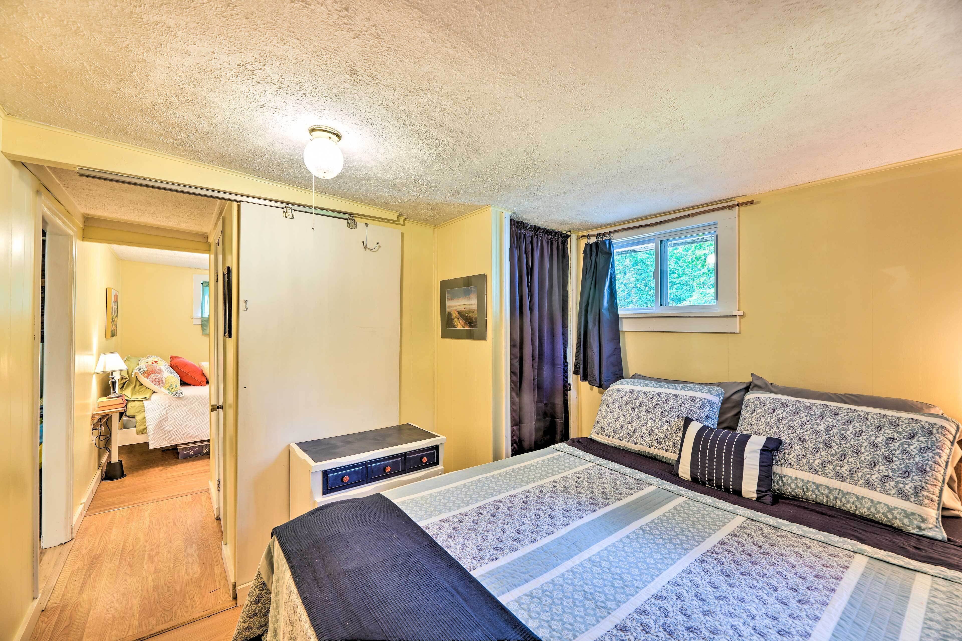 Ein Schlafzimmer mit einem Bett, Nachttischen und einem Fenster mit Vorhängen.