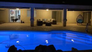 A pool area with a clear view of the pool, a seating area with a sofa and chairs, and a hanging chair. - Rocking Horse Retreat, pool, sleeps 10, lake view, minutes to launch & lake (Lake Havasu City)