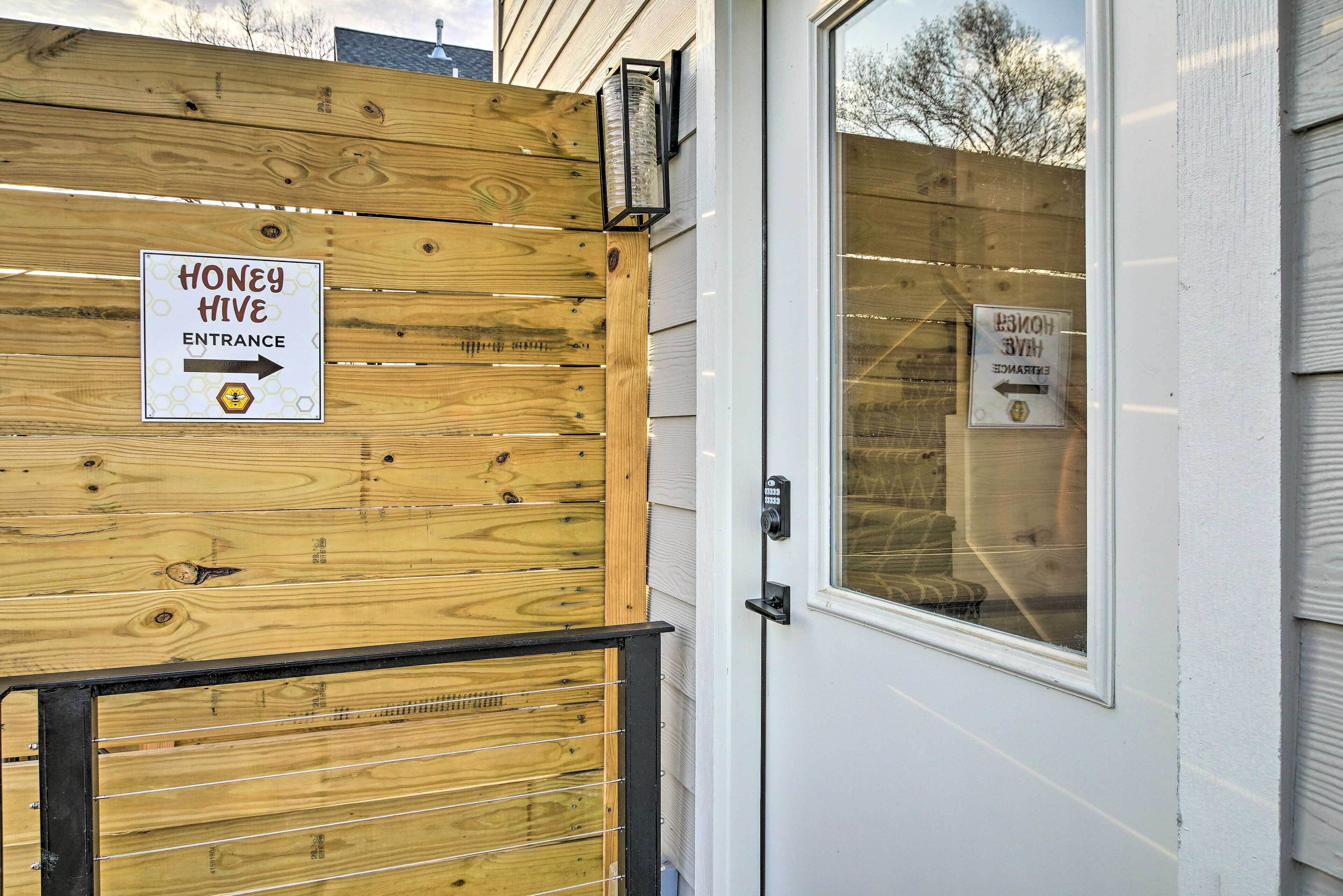 A wooden fence with a sign indicating the entrance to a honey hive.