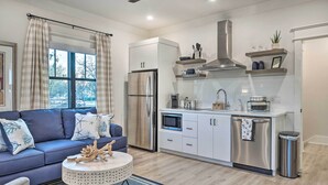 A modern kitchen with stainless steel appliances, white cabinetry, and a built-in microwave.