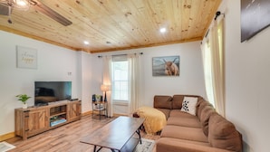A cozy living room with a wooden ceiling, a flat-screen TV, a sofa, and a coffee table. - 'creekside Ranch' w/ Porch ~ 2 Mi to Pkwy (Pigeon Forge)