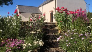 A building with a sloped roof and a door with a small porch. - Ty Rhosyn (Haverfordwest)