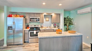 A modern kitchen with a stainless steel refrigerator, a microwave, and an oven. There is a large island with a basket of oranges and a plant. - Unwind Fireside! Poconos Cottage 12 Mi to Slopes (Brodheadsville)