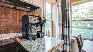 A kitchen with a coffee machine, a wooden countertop, and a window with curtains. - Lake Access & Kayaks: Gladwin Cottage Near Golfing (Gladwin)