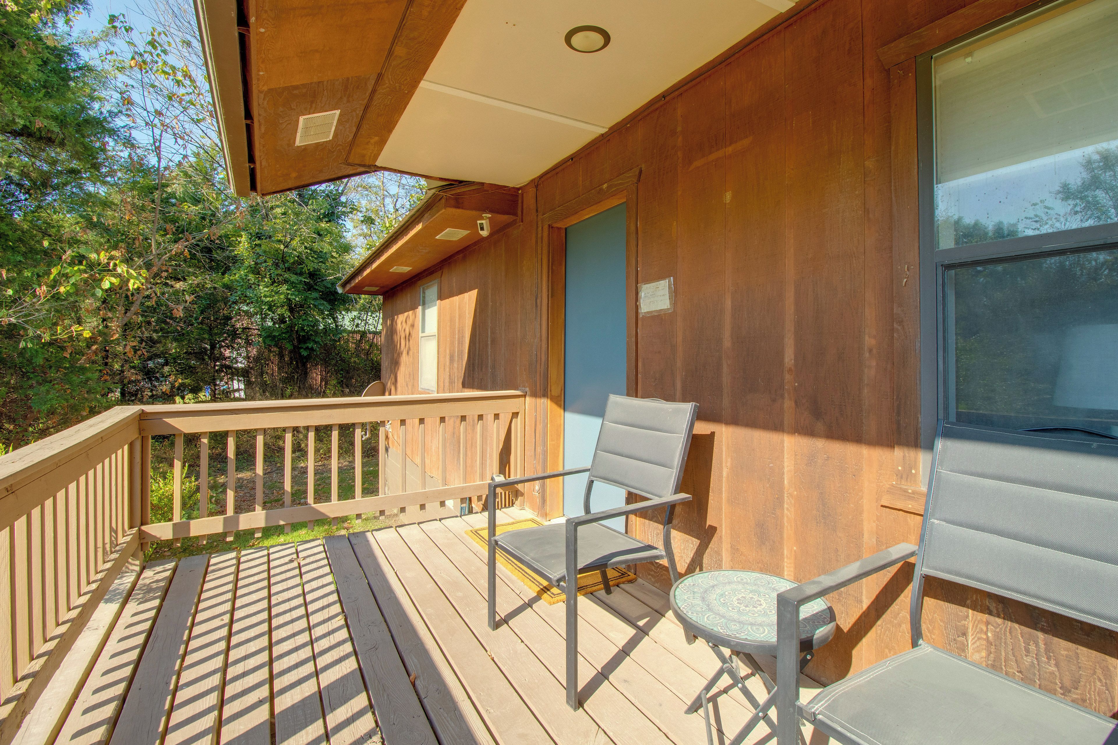 A wooden deck with a railing, a chair, and a table.