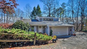 A two-story house with a garage, surrounded by trees and a gravel driveway. - Summer in the Smokies! Hayesville Bungalow w/ Deck (Hayesville)