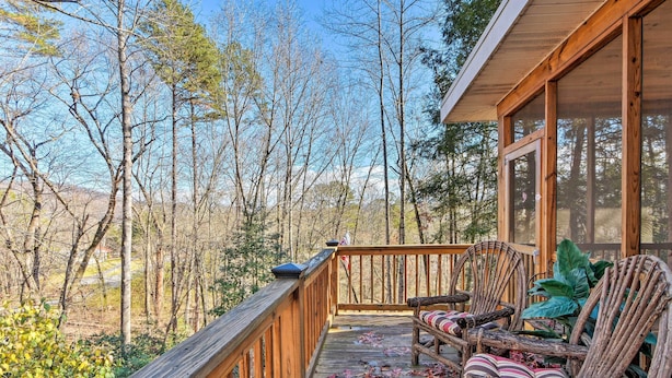 A wooden deck with a railing, two wicker chairs with cushions, and a view of a forested area. - Summer in the Smokies! Hayesville Bungalow w/ Deck (Hayesville)