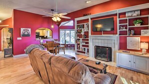 A living room with a fireplace, a television, and a bookshelf. - Summer in the Smokies! Hayesville Bungalow w/ Deck (Hayesville)
