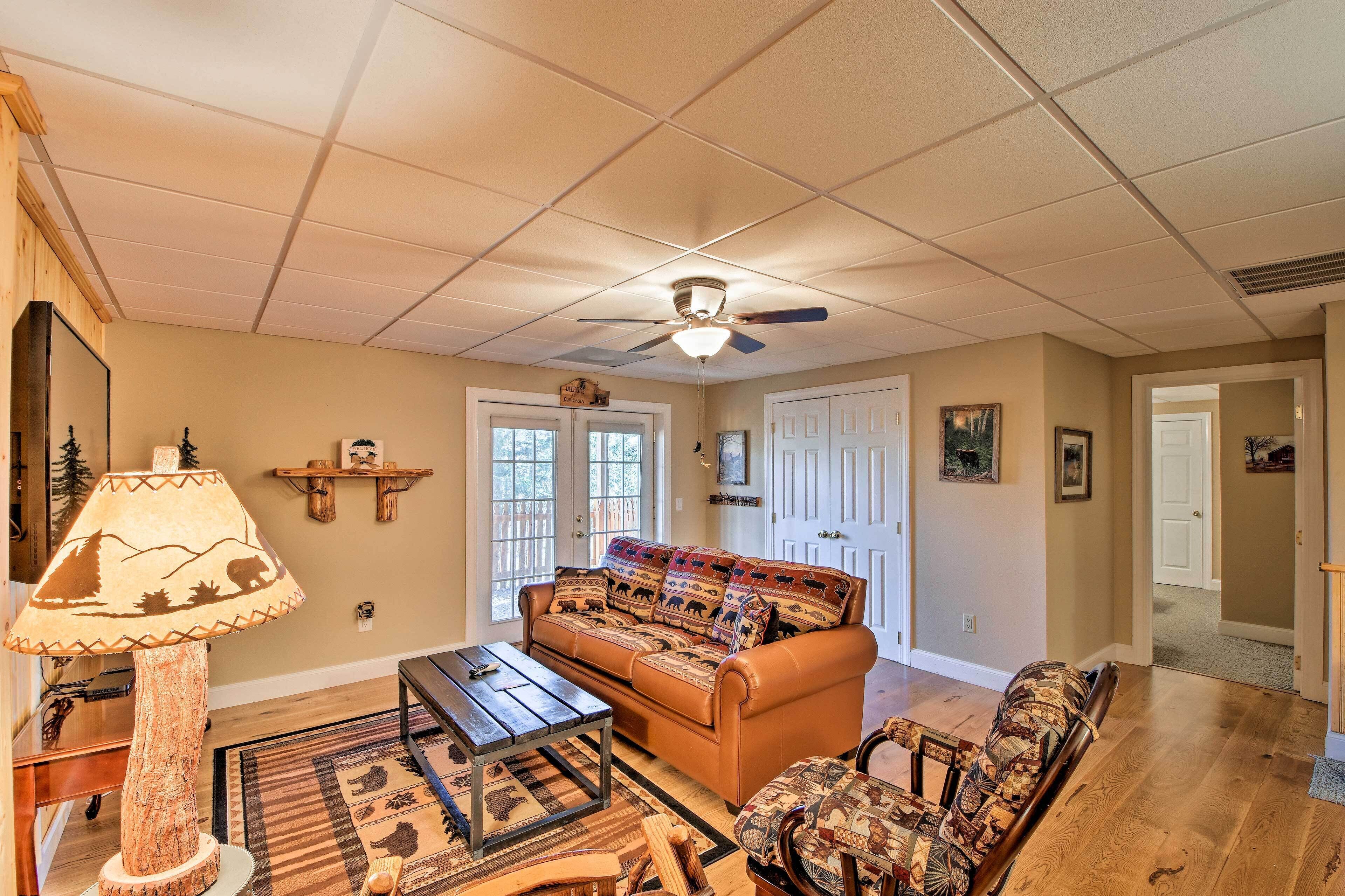 A living room with a sofa, a coffee table, a lamp, and a ceiling fan.