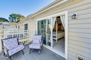 A covered outdoor area with two rocking chairs, a white railing, and a sliding glass door leading to a bedroom. - 2 Mi to Beach: Townhome w/ Breezy Balcony! (Rehoboth Beach)
