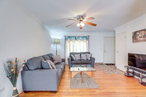 A living room with two grey sofas, a coffee table, a ceiling fan, and a door in the background. - Glendale Heights Home With Office and Backyard! (Glendale Heights)