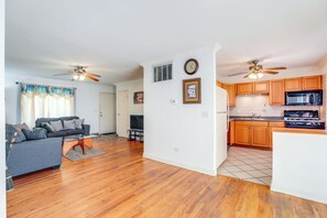 A spacious living area with hardwood flooring, a gray sofa, and a ceiling fan. - Glendale Heights Home With Office and Backyard! (Glendale Heights)
