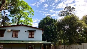Una casa de dos plantas con un porche cubierto y un pequeño jardín.