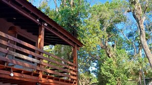 Una estructura de pérgola de madera con vistas a un jardín y árboles.