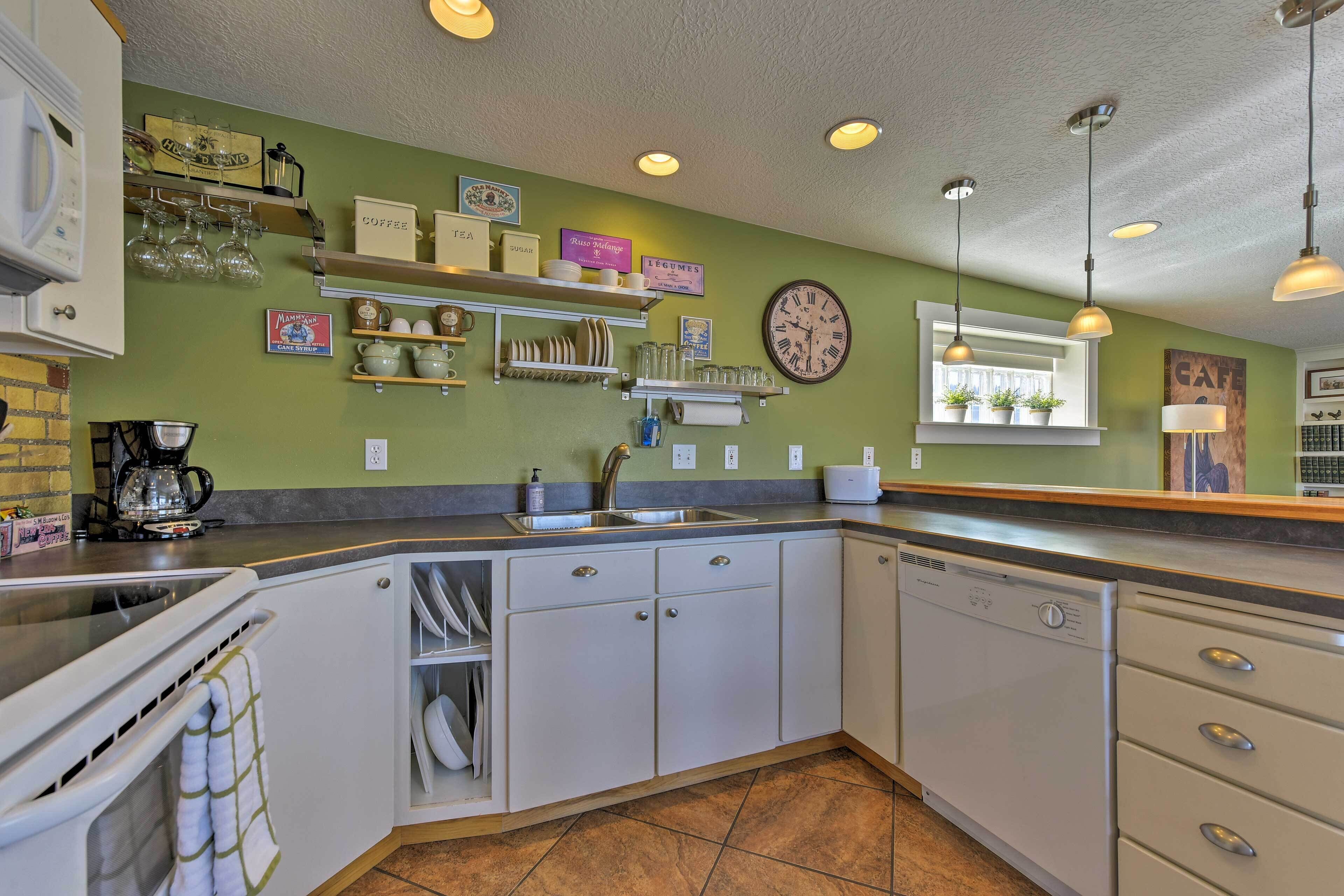 A kitchen with white cabinets, a dishwasher, a coffee maker, and various kitchen utensils.