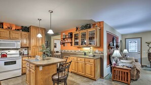 Una cocina con armarios de madera, una isla central y un comedor con un sofá.