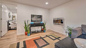 A modern living room with a flat-screen TV, a black entertainment unit, and a gray sofa. - Denver Area Duplex w/ Patio: Walk to Park! (Arvada)