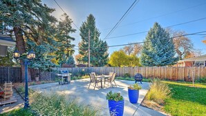 A backyard with a patio, outdoor furniture, and a wooden fence. - Denver Area Duplex w/ Patio: Walk to Park! (Arvada)