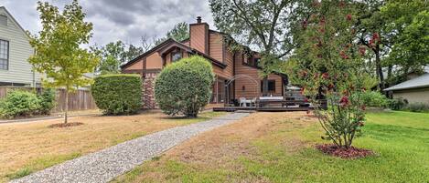 A residential house with a gravel driveway, a well-maintained lawn, and a patio area with outdoor furniture.