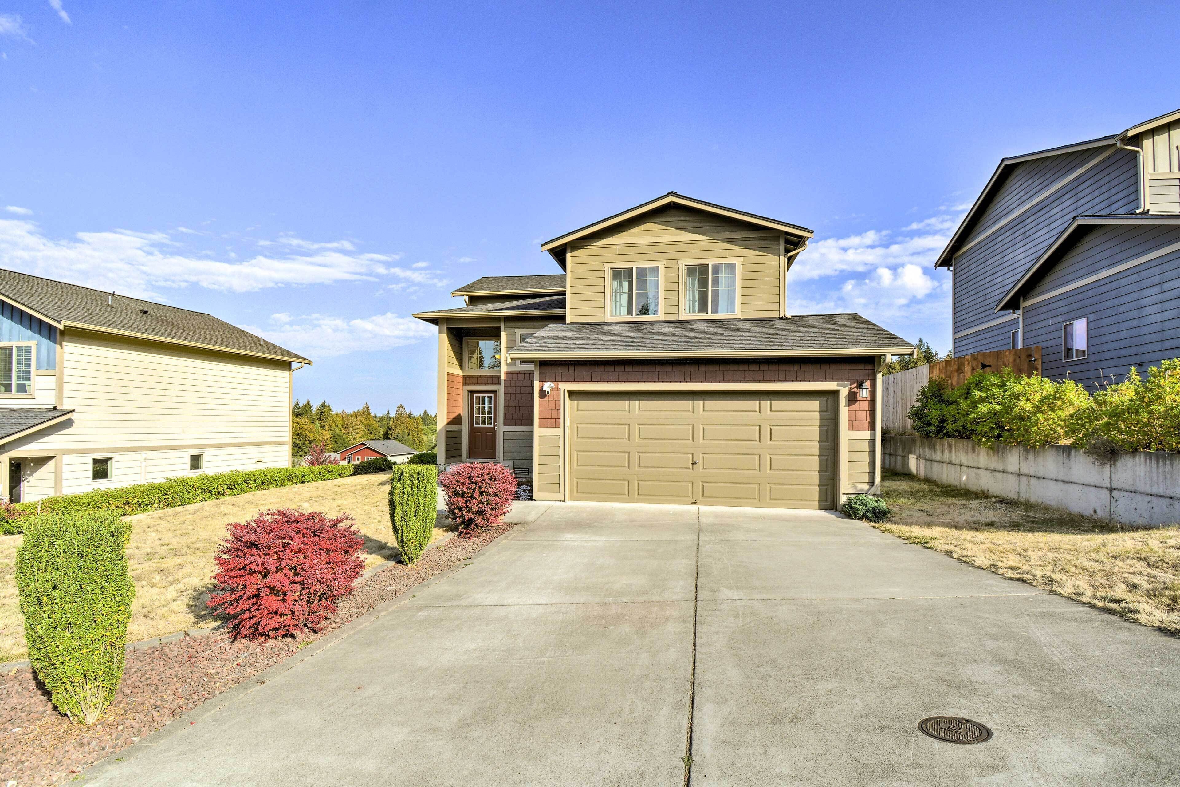 A residential house with a garage, a driveway, and well-maintained landscaping.