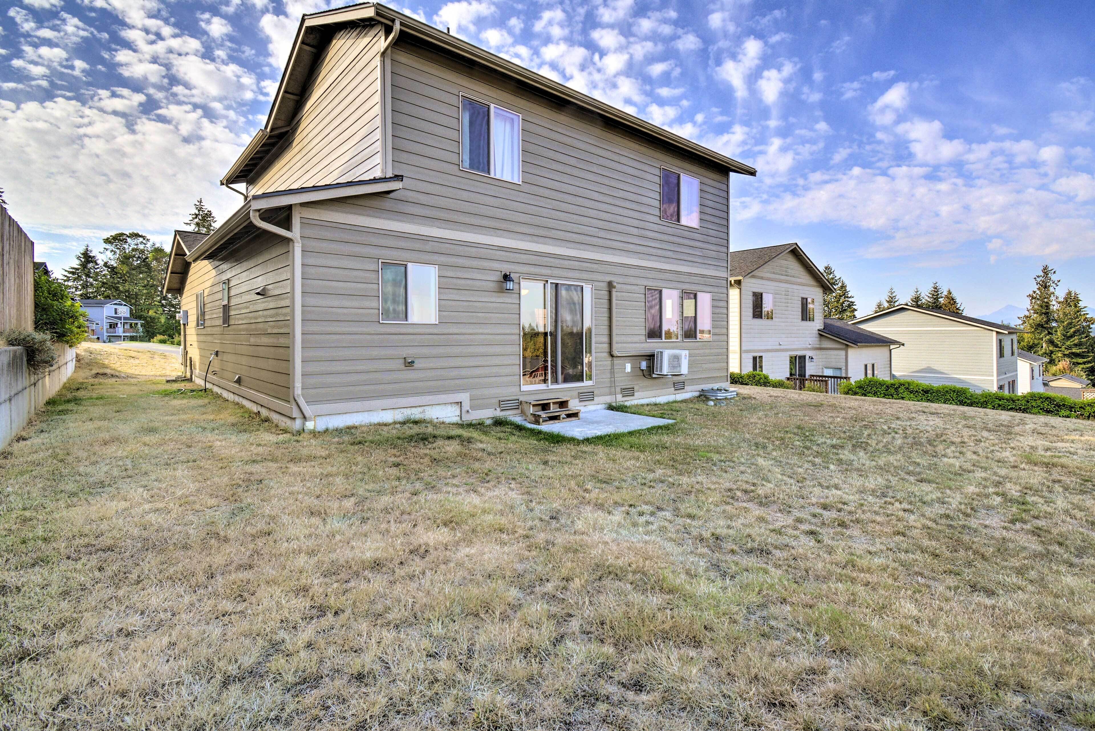 A two-story house with a front porch, a covered patio, and a small front yard.
