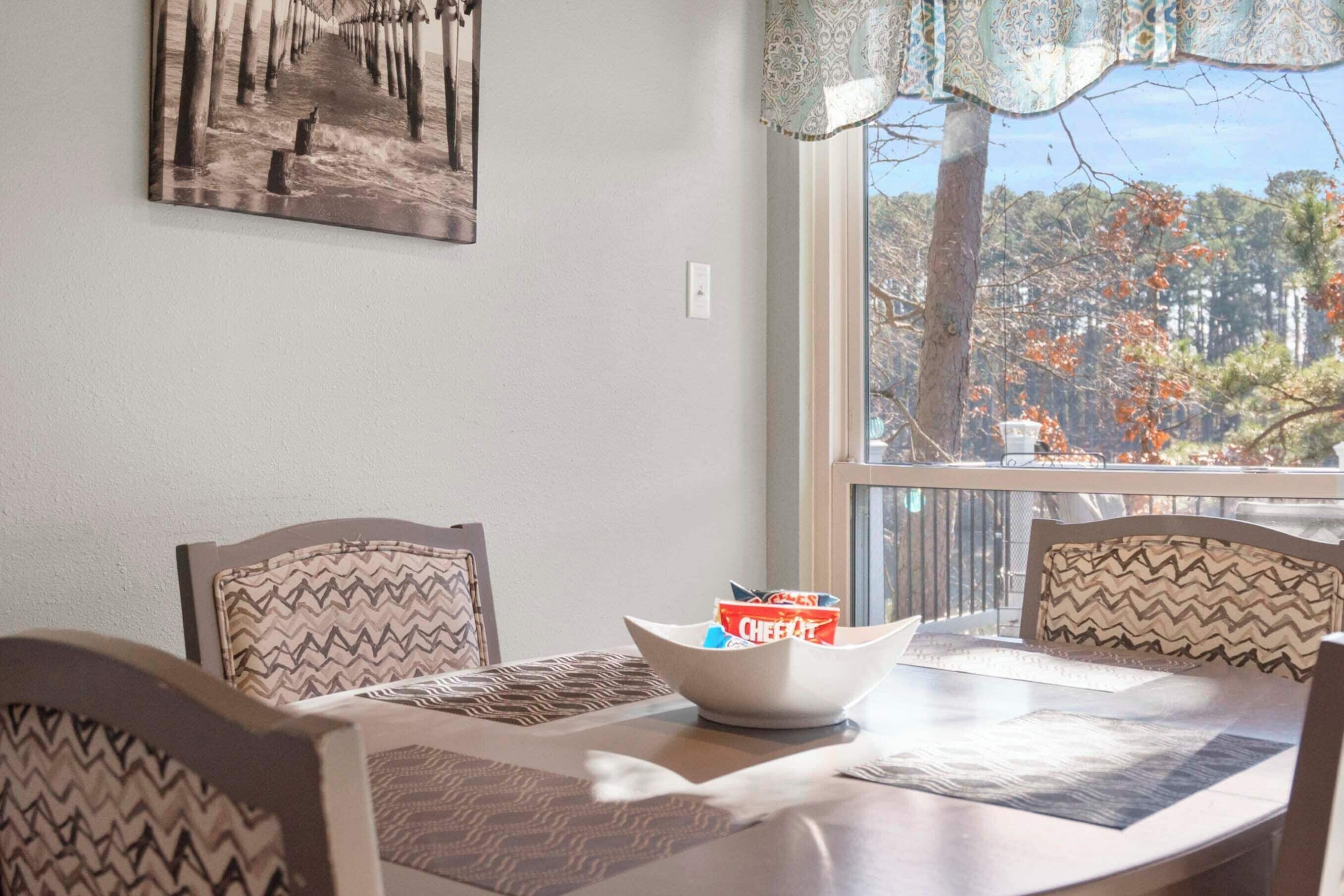A dining area with a table, chairs, and a bowl of cereal.