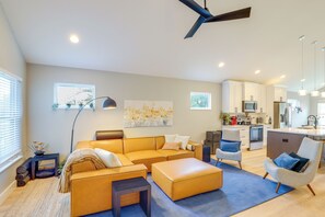 A modern living room with a sofa set, a coffee table, and a side table with decorative items. - Hot Tub & Fire Pit: Chic Asheville Oasis (Asheville)
