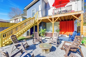 A patio area with outdoor furniture, a wooden deck, and a red umbrella. - Hot Tub & Fire Pit: Chic Asheville Oasis (Asheville)