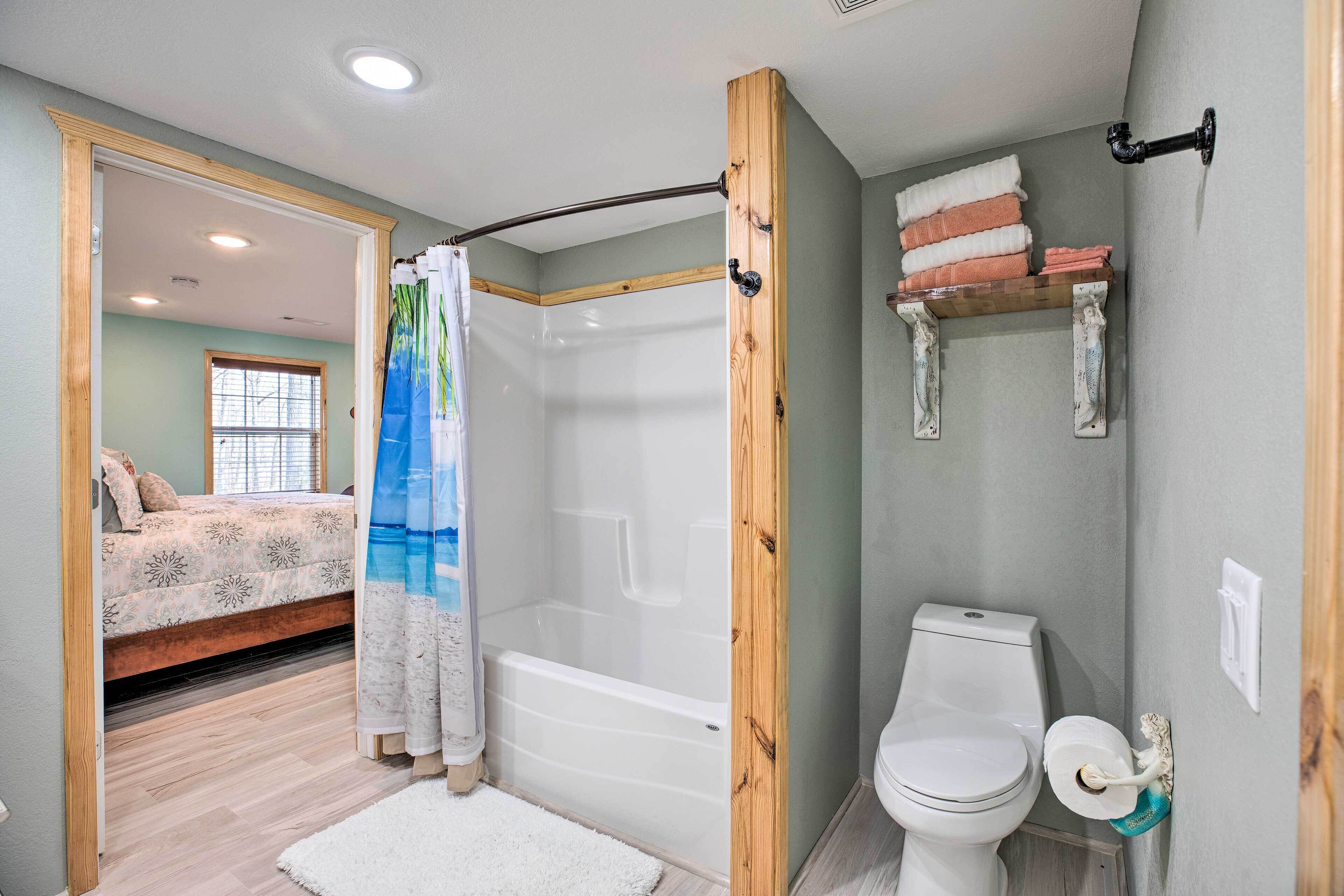 Une salle de bain avec une douche, des toilettes et une étagère avec des serviettes.