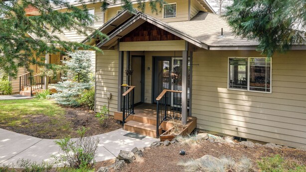 A two-story house with a front porch, a small garden, and a visible door. - Resort-style Klamath Falls Home, Golf Course View! (Klamath Falls)