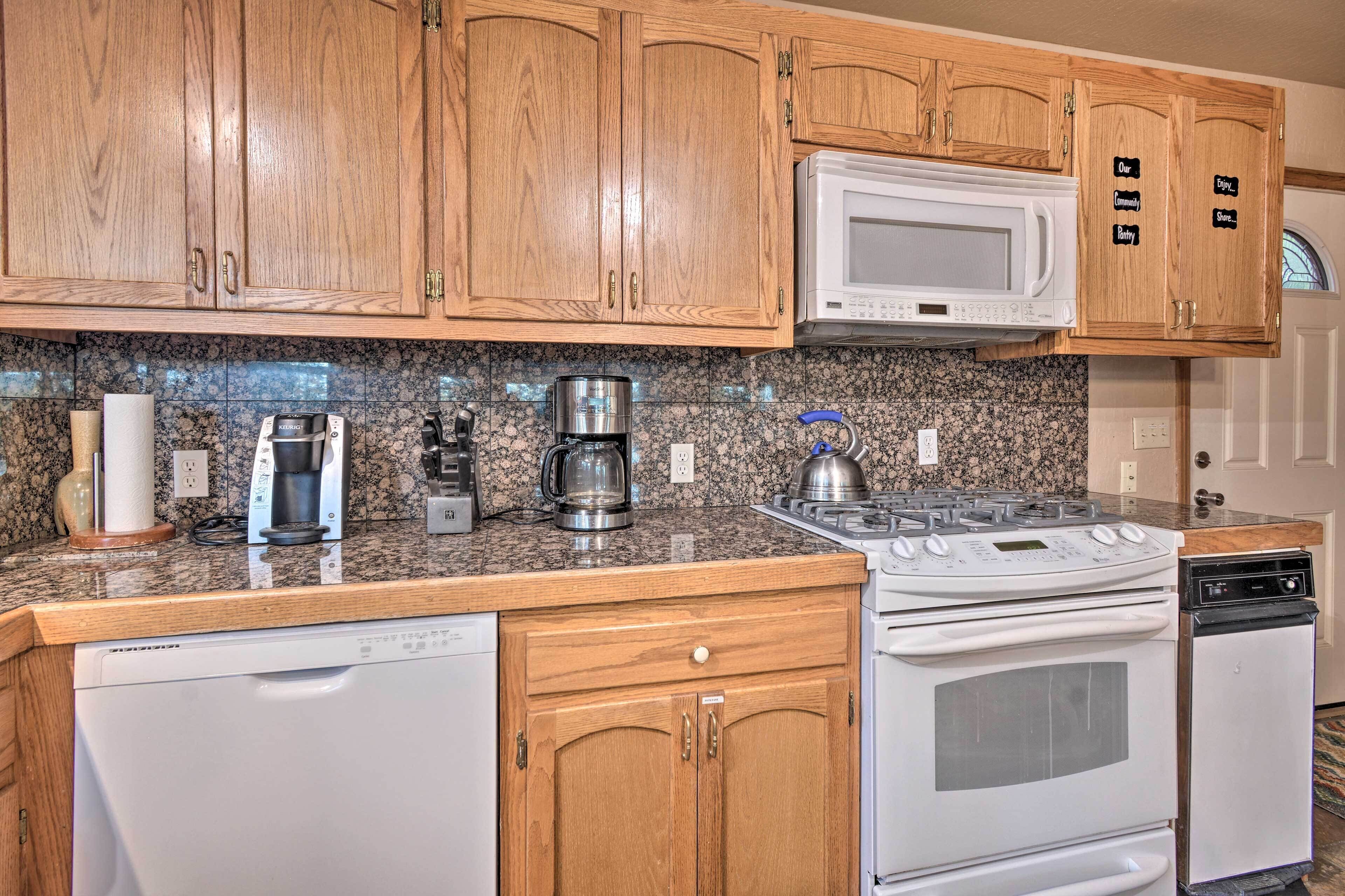 A kitchen with wooden cabinets, a microwave, a stove, and a dishwasher.