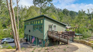 A green building with a wooden deck and a stone pathway. - Blue Ridge Retreat w/ Deck: Hike, Sip & Explore! (Asheville)