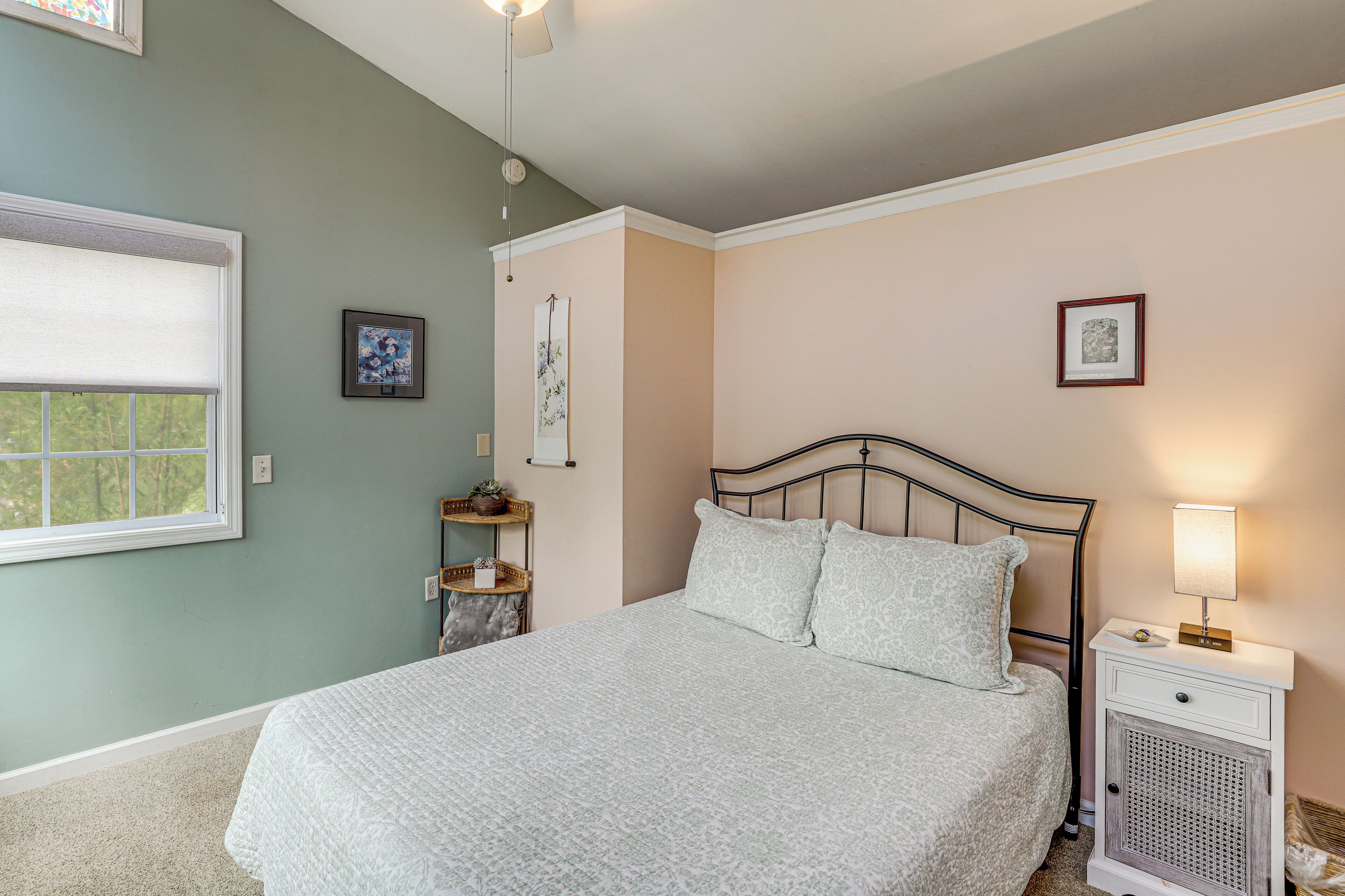 A bedroom with a bed, bedside table, and a window.