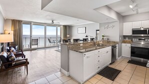 Una cocina moderna con armarios blancos, encimera de granito y electrodomésticos de acero inoxidable.
