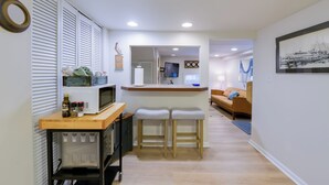 A compact kitchen with a microwave, bar stools, and a small counter. - Cozy Ventnor Getaway: Walk to Public Beach! (Ventnor City)
