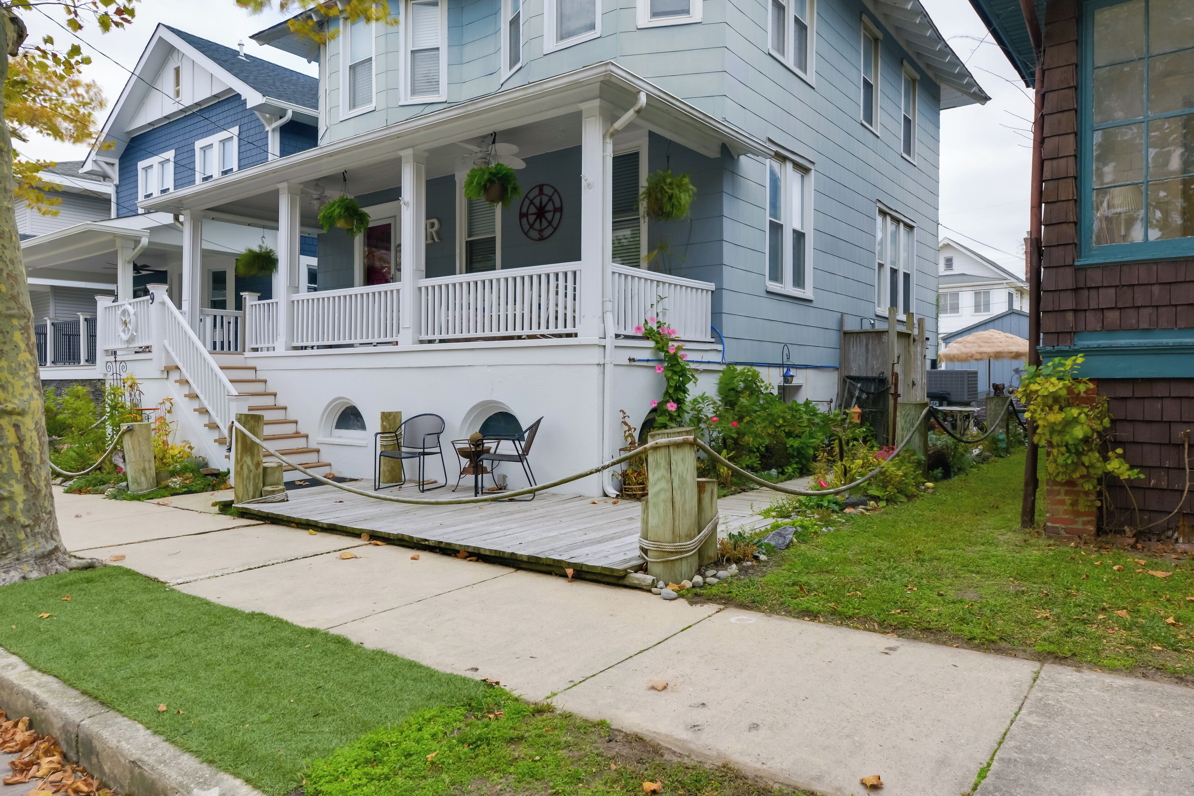 A two-story house with a porch, a staircase, and a small deck.