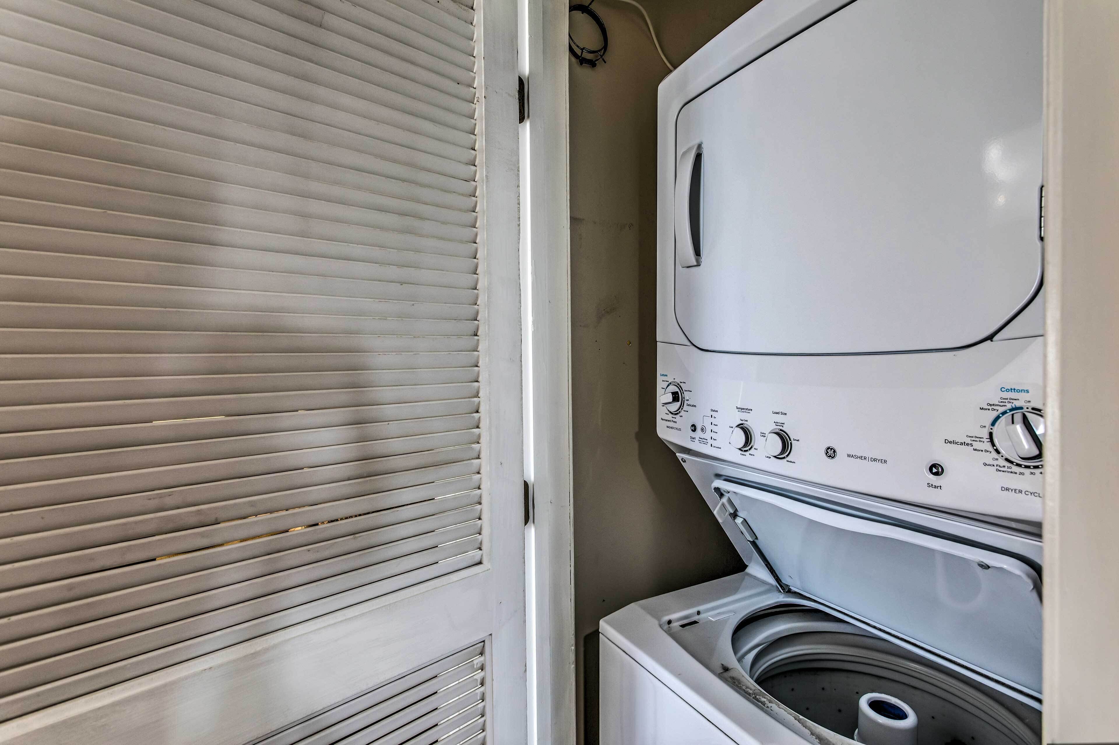 Una lavadora de carga frontal con panel de control, un secadora y un compartimento de secado ventilado.