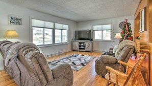 A living room with a fireplace, a TV, and a Christmas tree. - Cozy Postville Retreat w/ Fireplaces & Yard! (Postville)