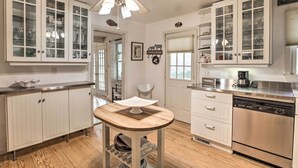 A kitchen with white cabinets, a wooden table, and a dishwasher. - Spacious Faber Home w/ Yard, Steps to Winery! (Faber)