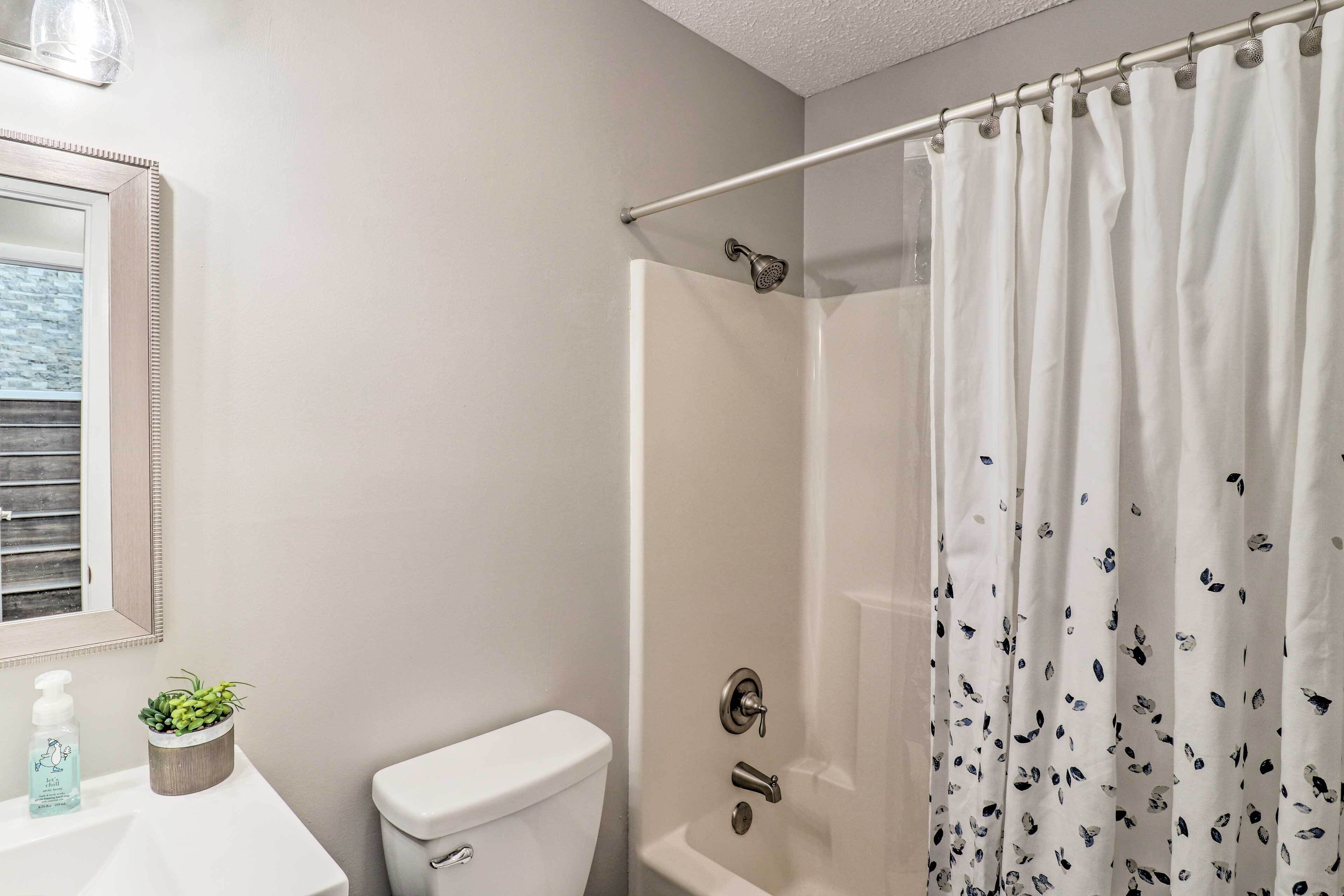 Une salle de bain avec douche, toilettes et lavabo.