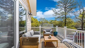 A deck with a sofa, chairs, and a coffee table. - Family Friendly 5 Bedroom, Walk to Town, Beach & Ferry (Tisbury)