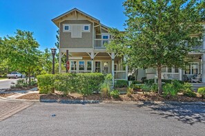 A two-story residential building with a balcony on the second floor, a covered front porch, and a driveway with a stop sign. - Beach Oasis w/ Pool Access, ~ 1 Mi to Shore! (Santa Rosa Beach)