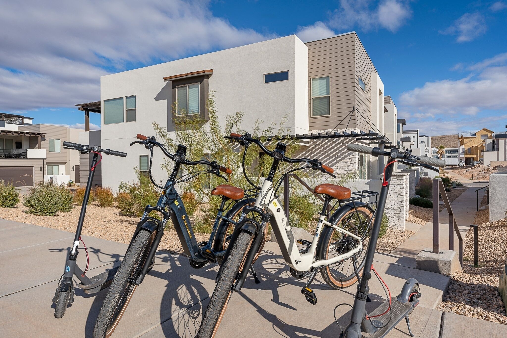 Two bicycles parked in front of a modern building with a clear sky.