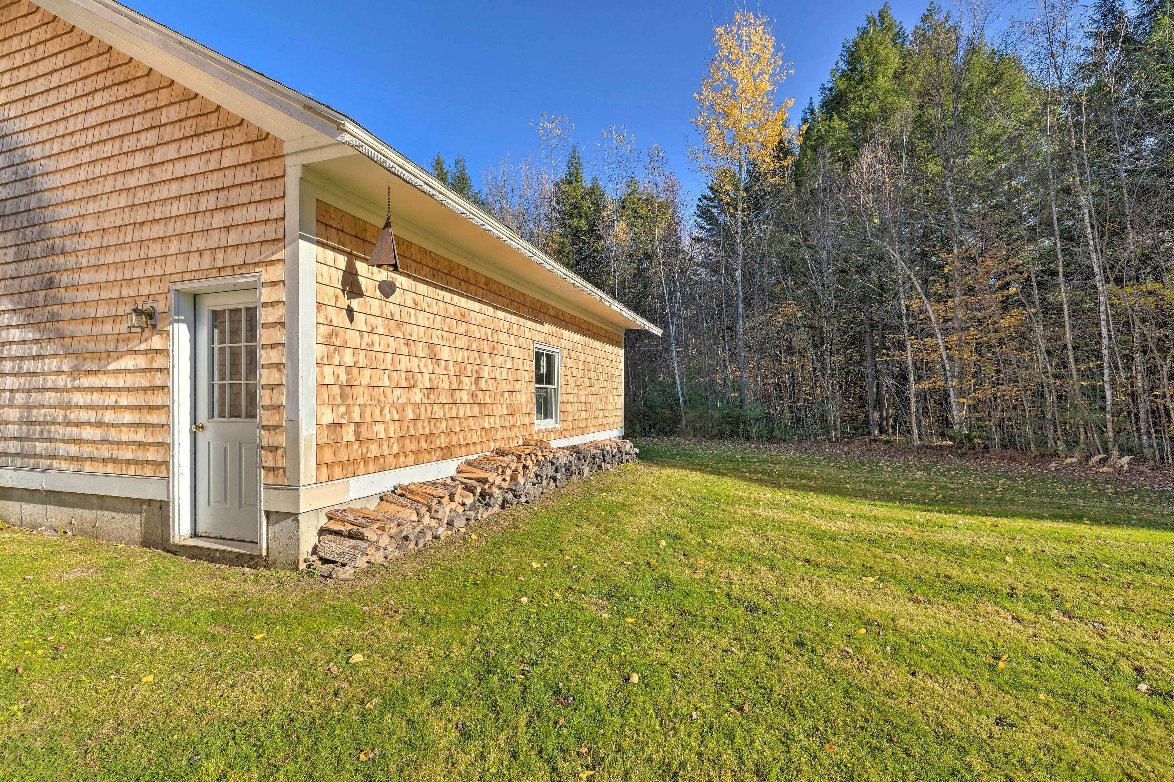 A wooden cabin with a front door, a small window, and a stone foundation.